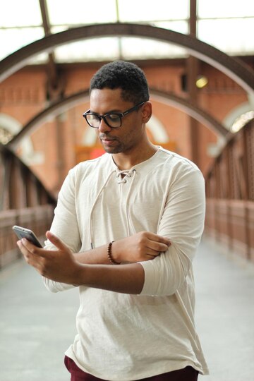 man-wearing-white-shirt-black-glasses-holds-phone-his-hand_914563-4